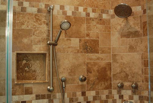 Custom stone shower enclosure with adjustable hand held shower.